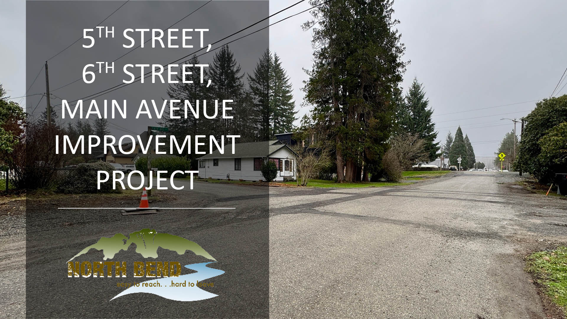 An asphalt road and gravel with text describing an infrastructure project